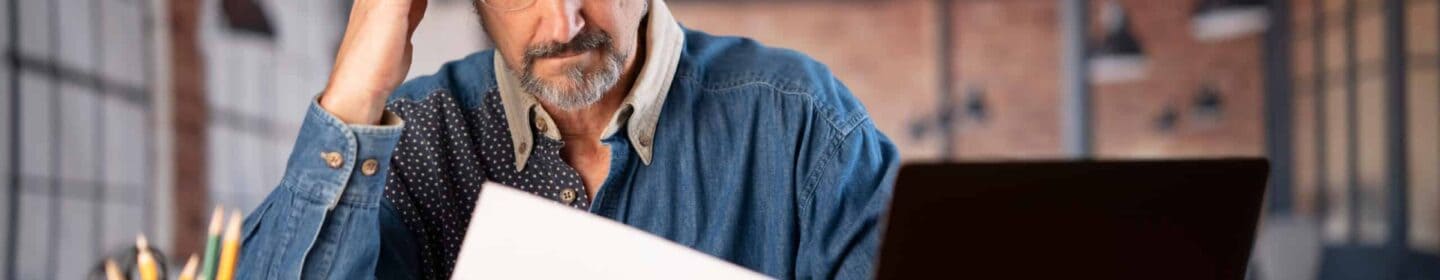 Man Stressed at His Laptop After Reading IRS Notice CP523A